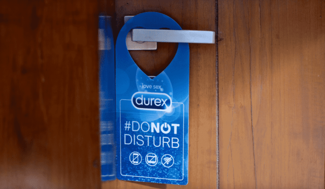A sextech door hanger displaying the word "Durex" in blue.