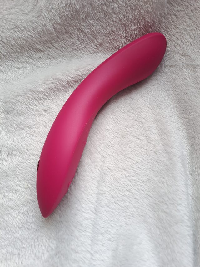 A pink we-vibe toy on a white blanket.