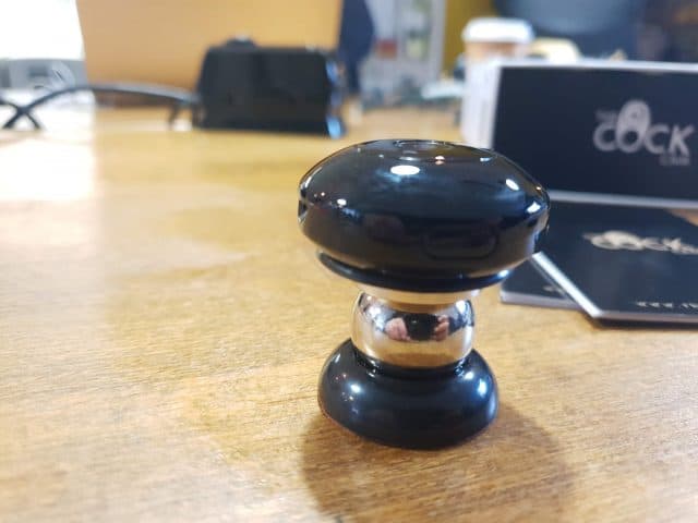 A tiny black device positioned on a table; CockCam review.