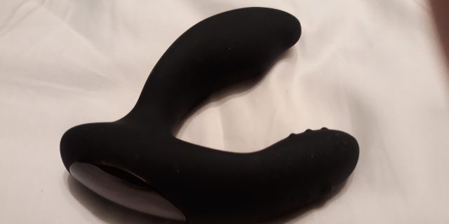 A Lovehoney Desire Prostate Vibe lying on a bed.