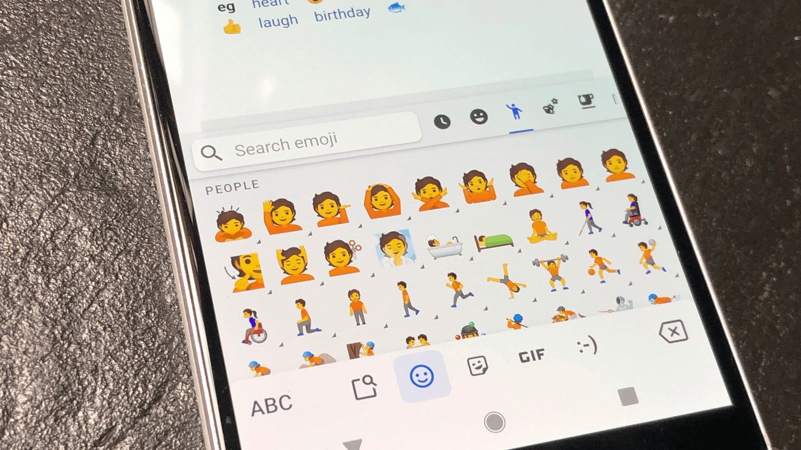 A smartphone with gender-inclusive emojis displayed on the screen.