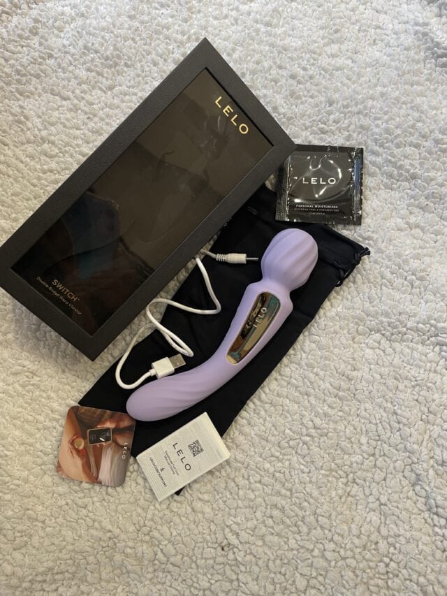 Luxurious LELO Switch double-ended vibrating wand with remote control, charging cable, instruction manual, and packaging, designed for elite adult pleasure and intimate wellness.
