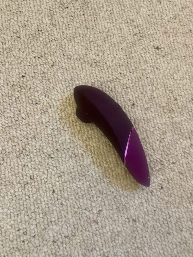 A purple plastic object is sitting on a carpet, awaiting its next review.