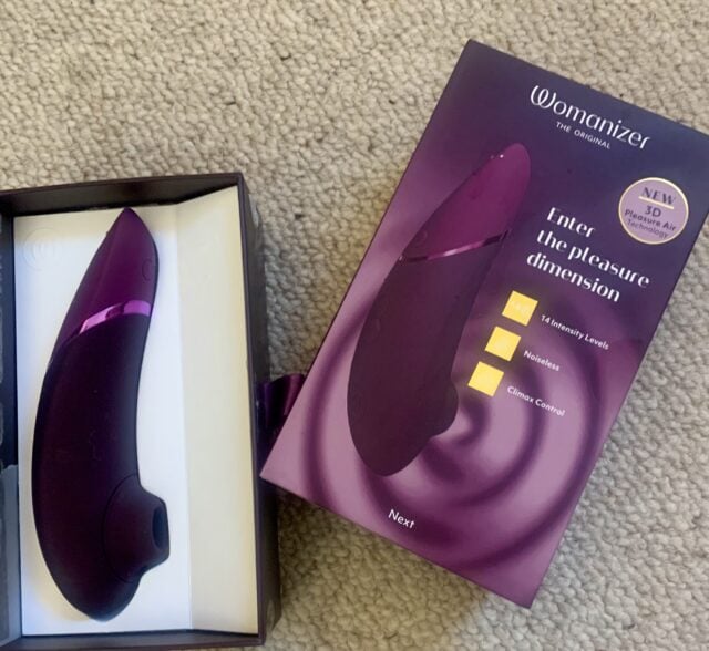 A purple vibrator is available for the next review, neatly placed in a box on the floor.