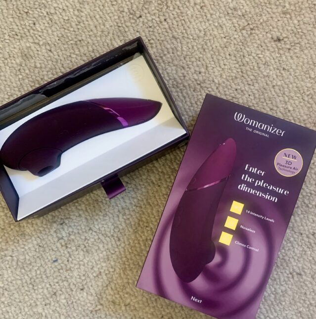 A purple vibrator with a box next to it.