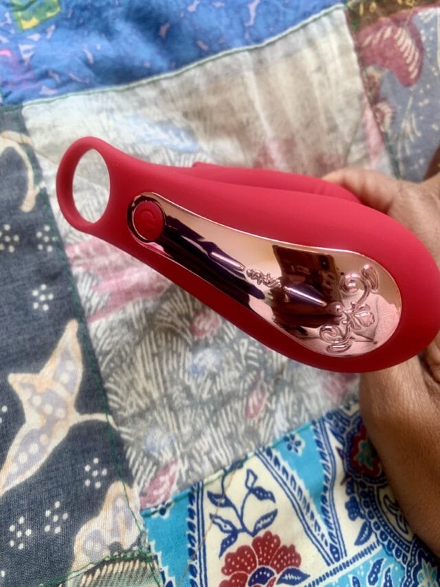 Pink sex toy with metallic accents, sleek design, and textured surface, designed for sensual pleasure and intimacy enhancement.