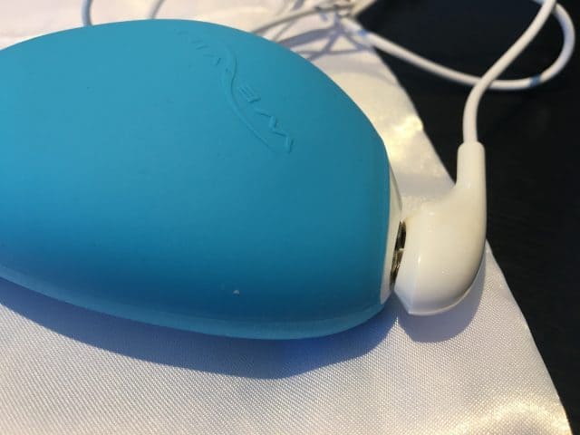 A blue mp3 player with we-vibe wish earphones on it.