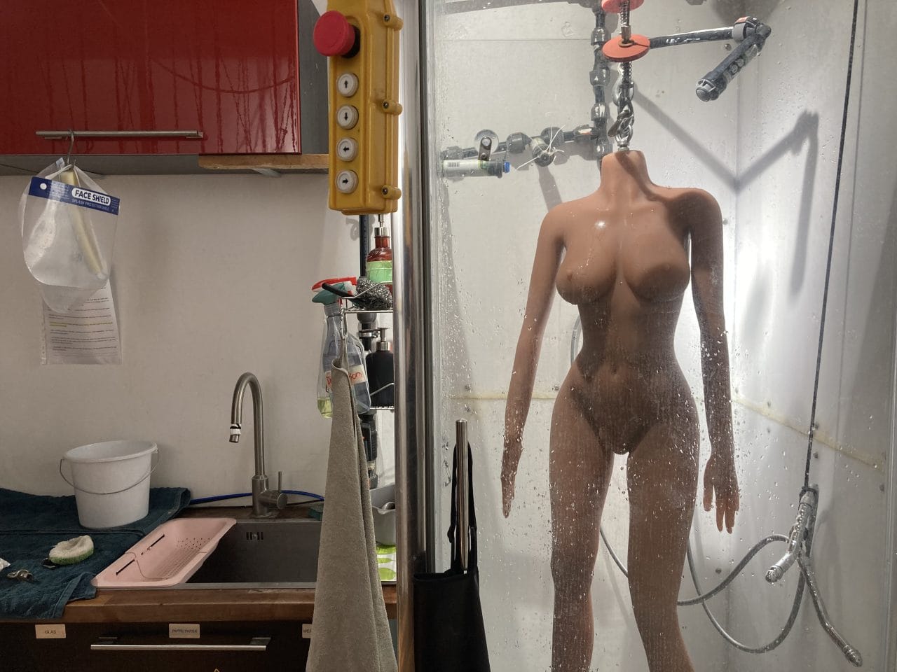 A mannequin in a bathroom with a shower at a cyberbrothel.