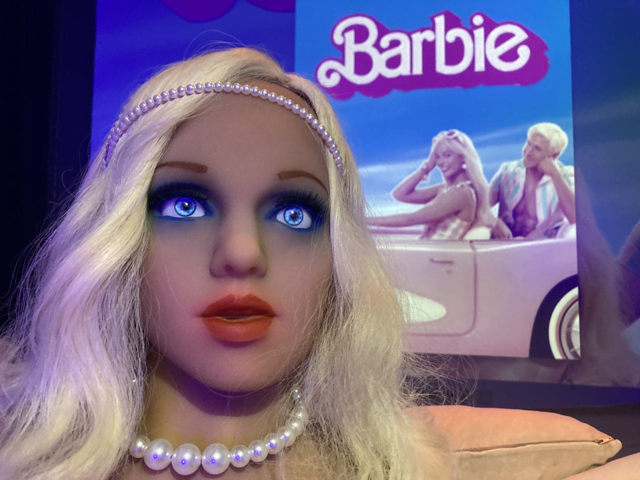 A Barbie doll is sitting in front of a television at the Barbie Cyberbrothel.