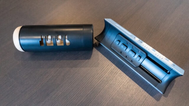Compact sex tech device with remote control and modern design, featuring sleek black and silver finishes for enhanced intimacy and pleasure.