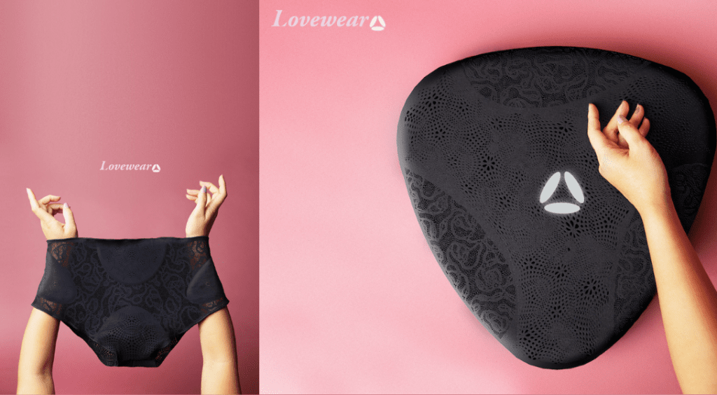 Lovewear Witsense A woman's hand holding a black bra on top of a pink background showcases lovewear, hi-tech underwear that simulates touch.