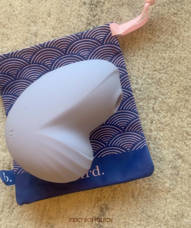 A blue and white Namii sex toy is placed on a carpet.