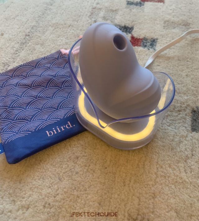 A blue Namii device on a rug next to a bag.