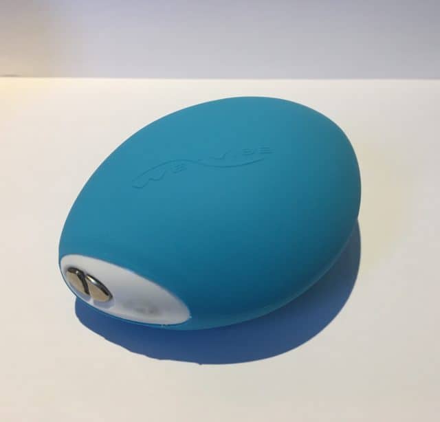 A blue plastic ball, resembling the we-vibe wish, resting on a white surface.