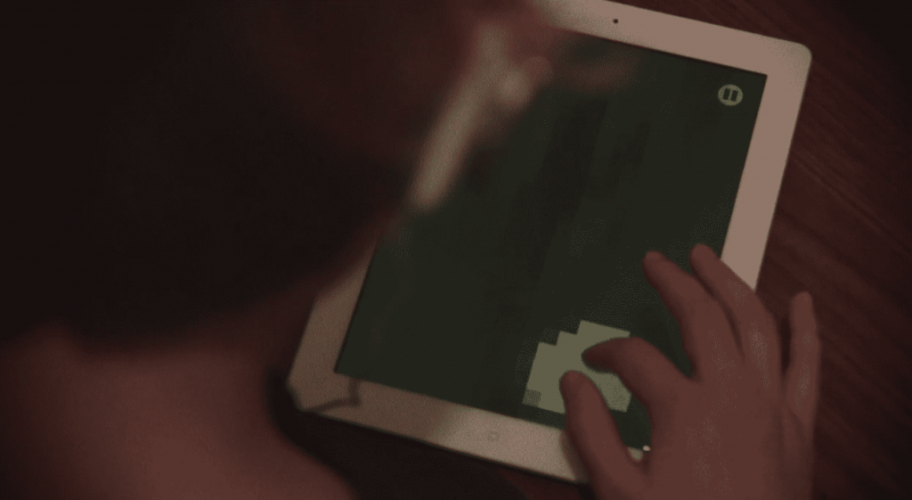 A person is using an iPad on a table while Apple deems controversial content as 'crude' for users.