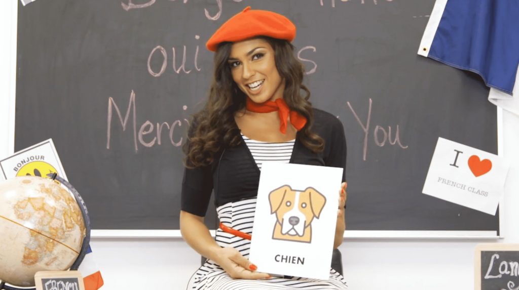 A performer in a red hat is holding up a sign.