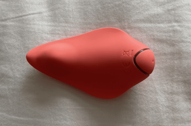 In-depth review of the discreet and innovative Clandestine Companion panty vibe, featuring a vibrant red toy showcased on a bed.