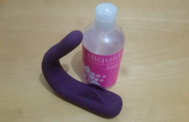 A vibrating mystery sex toy, the MysteryVibe Crescendo, showcased alongside a liquid bottle.