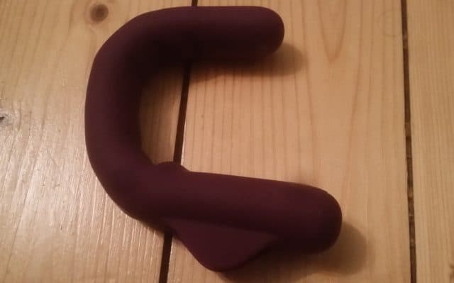 A review of the MysteryVibe Crescendo, a versatile sex toy in a charming purple color, placed on an elegant wooden floor.