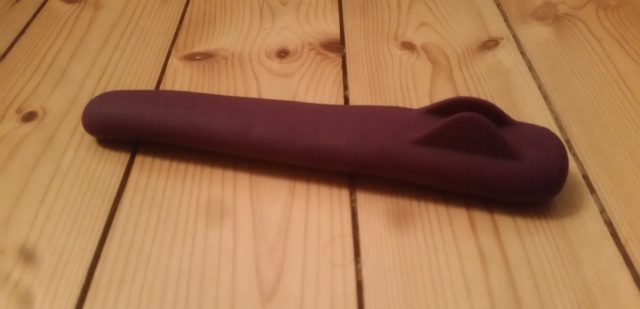 A purple plastic toy lying on a wooden floor, left reviewers intrigued with its MysteryVibe Crescendo.