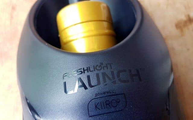 A black bottle with a yellow label for Fleshlight Launch review.