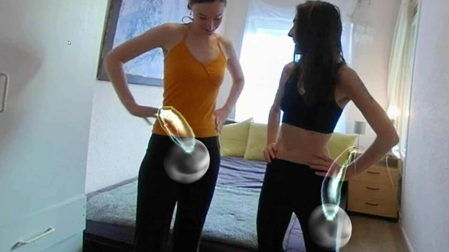 Two women engaging in XtraSexyReality experience in a room.
