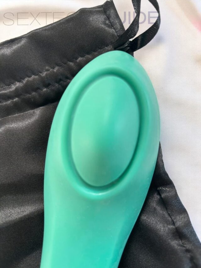 Silicon sex toy in turquoise color placed on a black storage bag, designed for intimate pleasure, discreet and body-safe material.