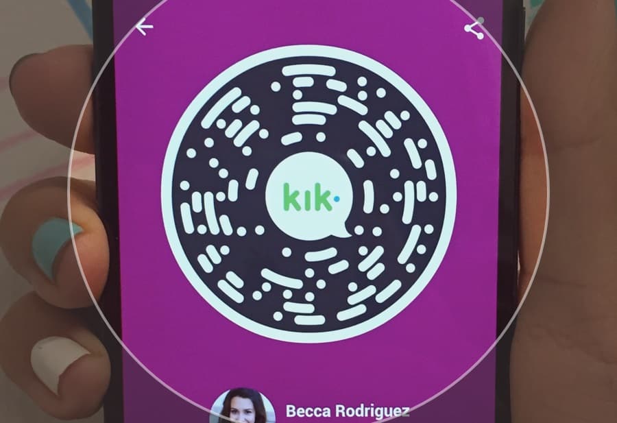 A person is holding up a cell phone with the word klik on it, while Kik wins control of 9 cybersquatting sites.