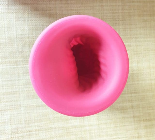 A Lelo F1s review of a pink plastic cup with a hole in it.