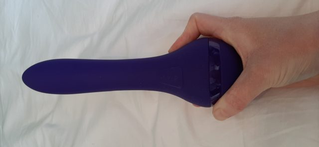 A person holding a Lovehoney Gyr8tor on a bed.