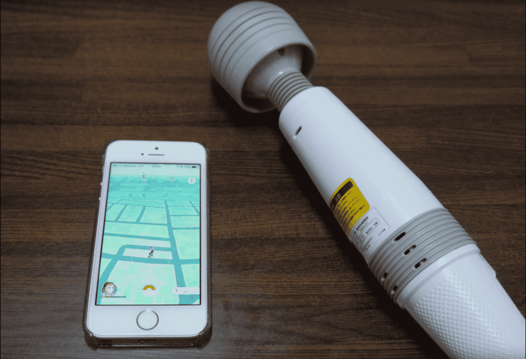 A phone and a pokemon toy on a table.