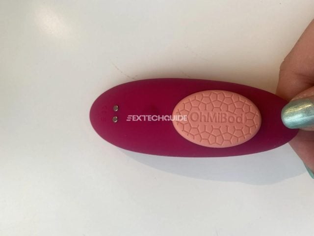 A person holding a foxy pink device with pink nail polish on it.