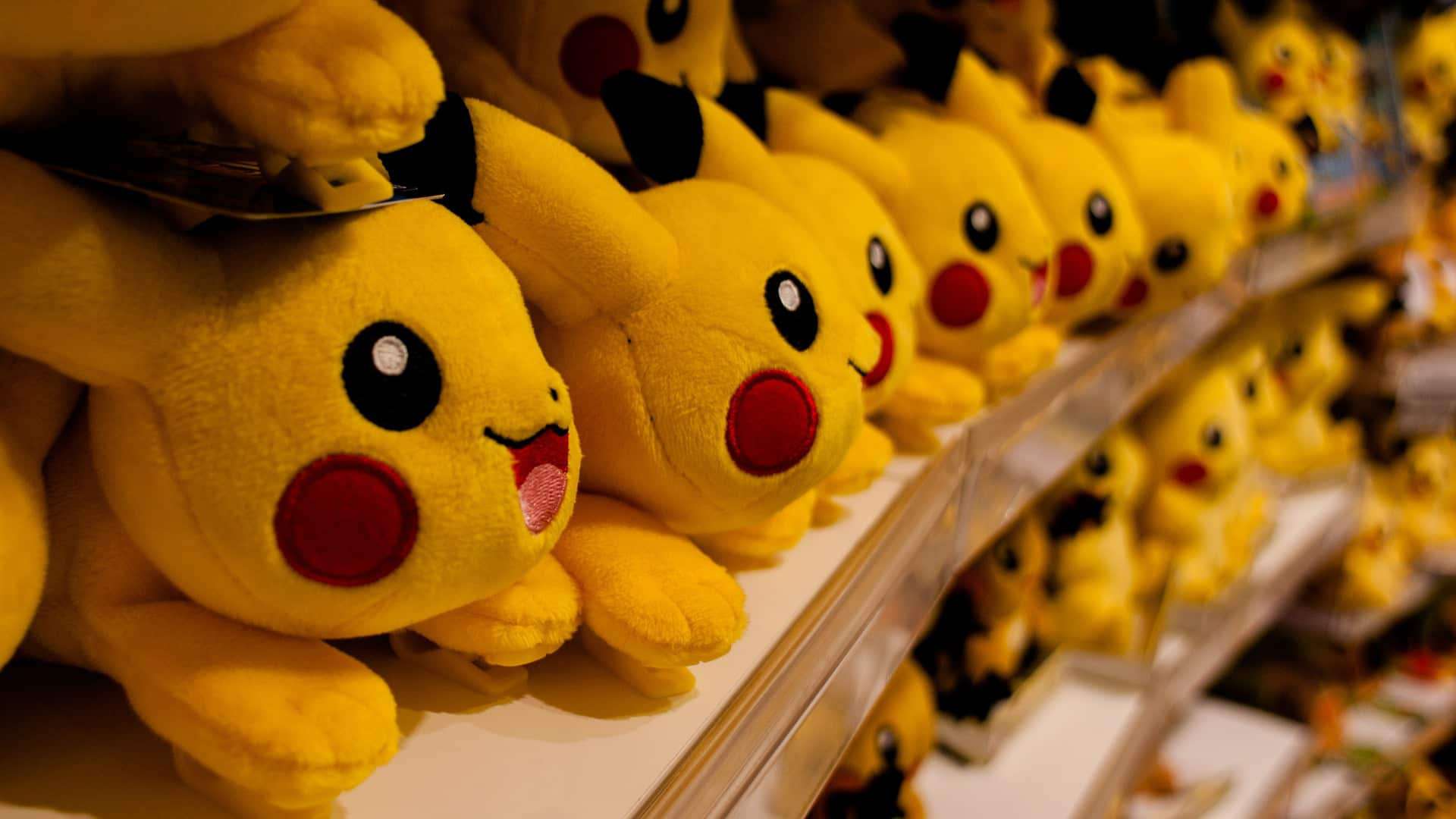 Pokemon pikachu plush toys are lined up on a shelf. (No modifications made)