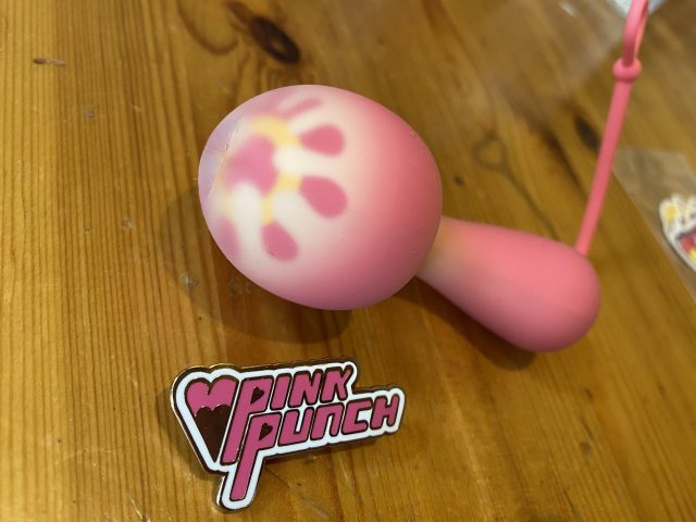 A whimsical PinkPunch Sunset Mushroom sex toy with a sticker on it.