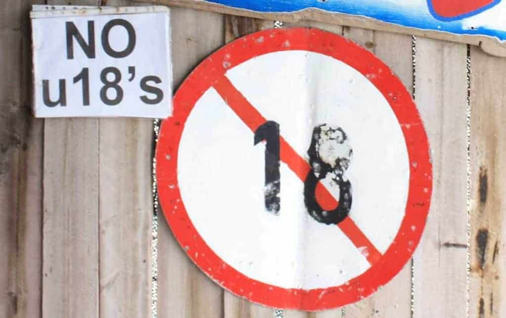 Wooden fence displaying warning about UK's impending porn verification rules.