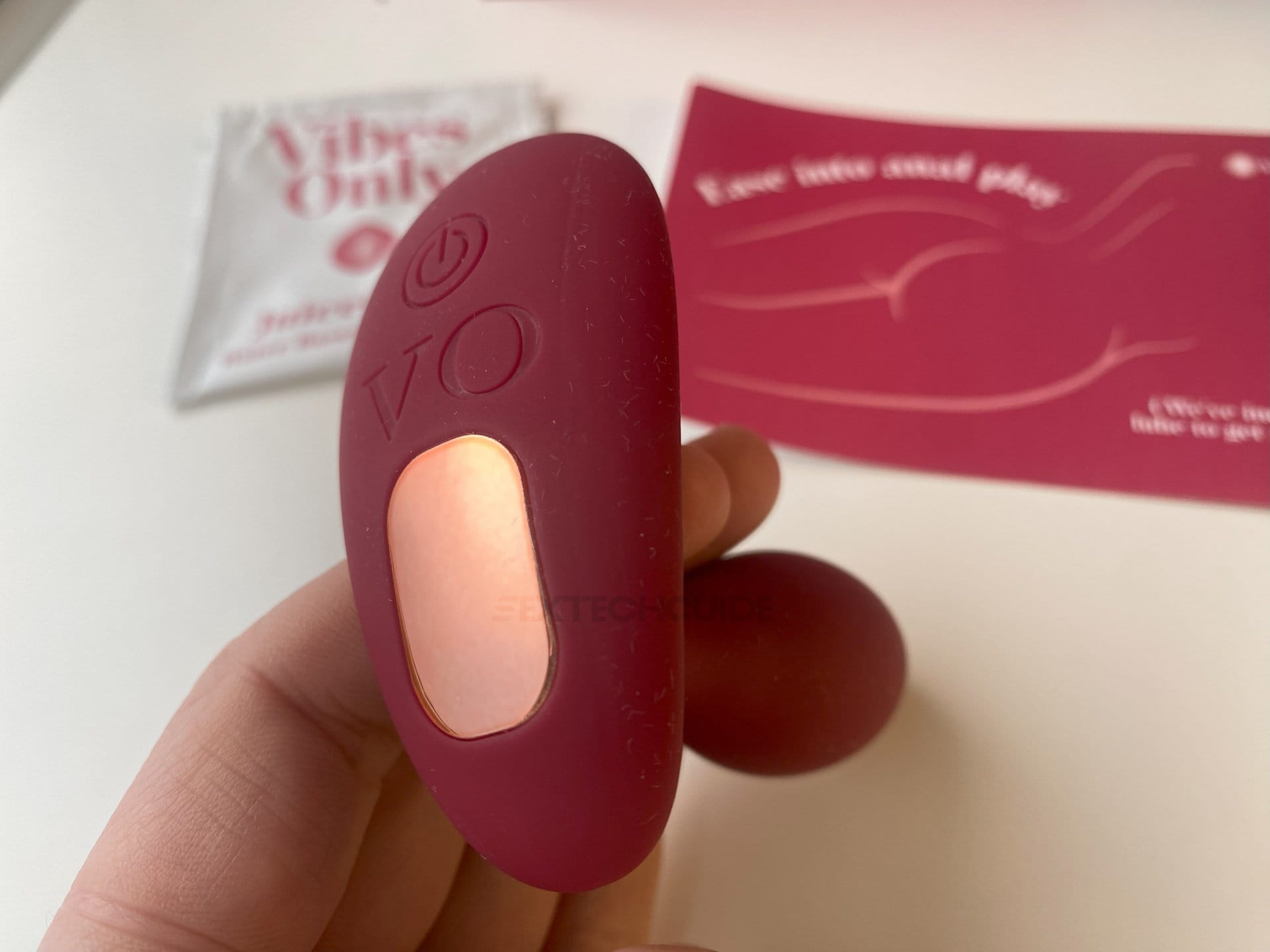 A person is holding a red vibrator, experiencing the stimulating vibes.