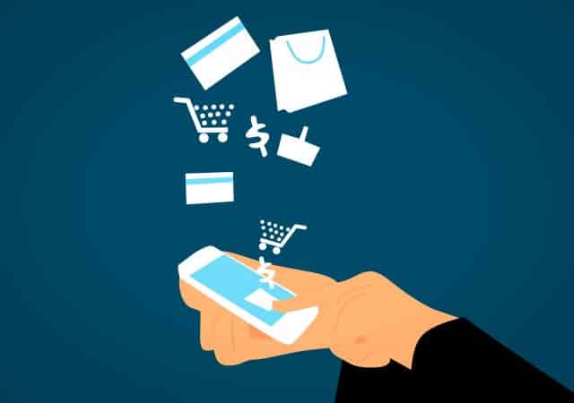 A hand holding a smartphone with shopping items flying out of it, demonstrating the convenience of payment processors.