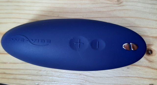 A blue button on a wooden table.