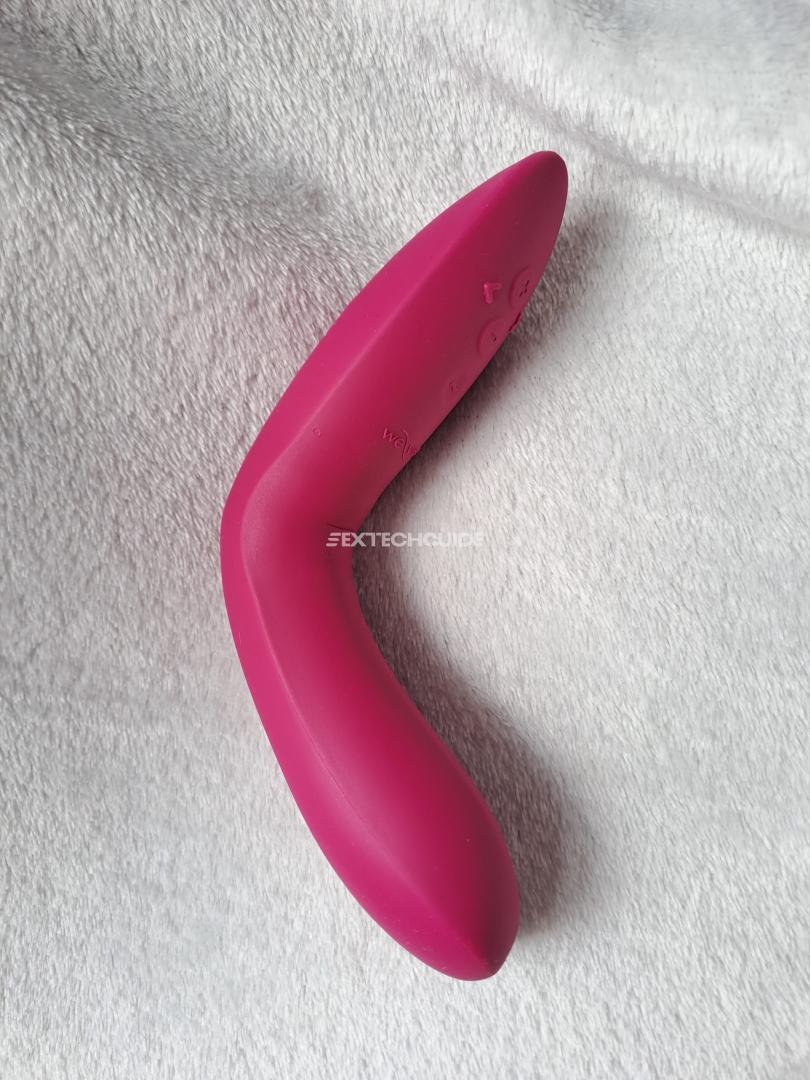 The We-Vibe Rave 2, a pink vibrating toy, rests comfortably on a soft white blanket.
