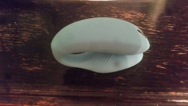 A blue WeVibe Sync toy sitting on top of a wooden table.