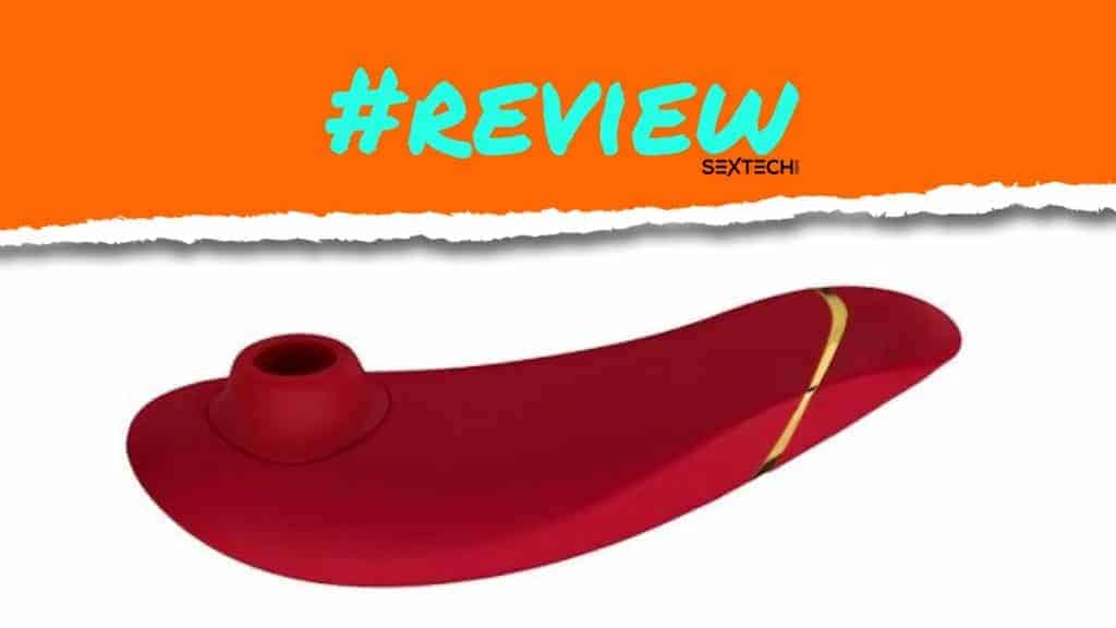 A Womanizer Premium adorned with the words "review" on a vibrant red pipe.